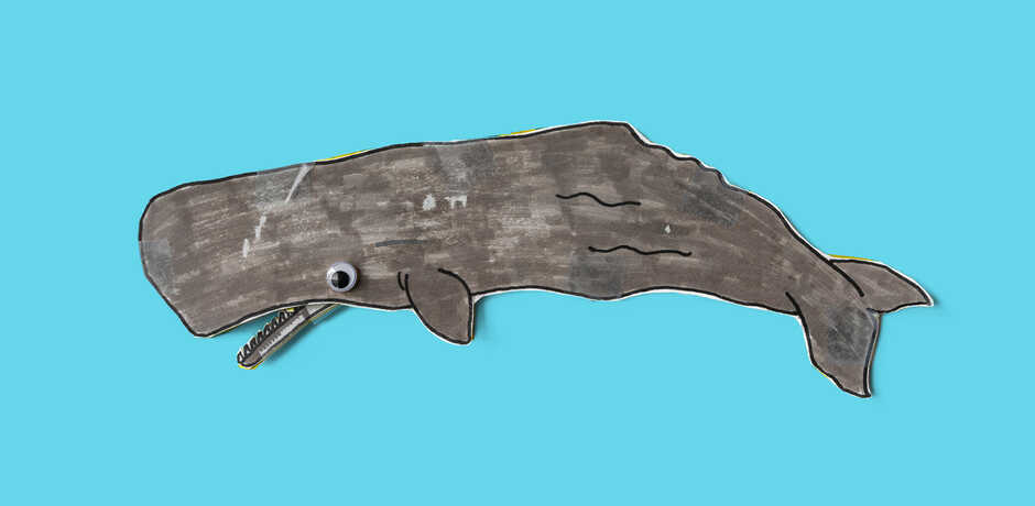 Cute craft of paper sperm whale against blue background