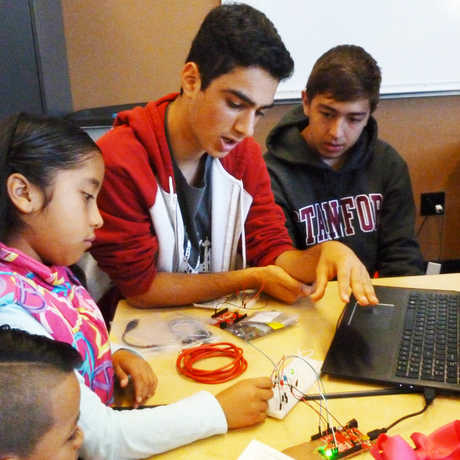 Teen-helps-kids-with-laptop-and-circuit-board_Credit-Bay-Area-STEM-Ecosystem