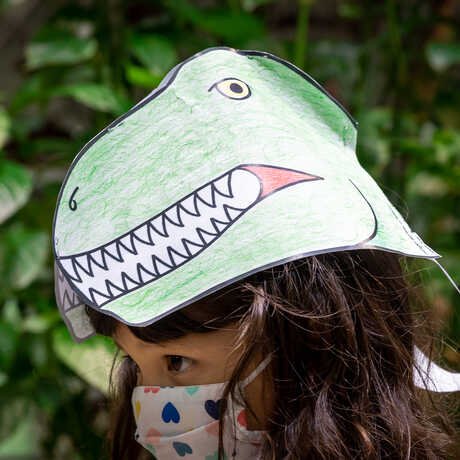 Girl wearing a paper T. rex hat