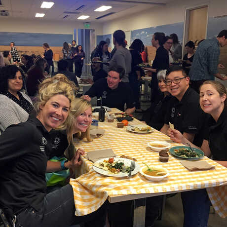 A group of veggie-loving staff enjoy a vegetarian community potluck at work. 
