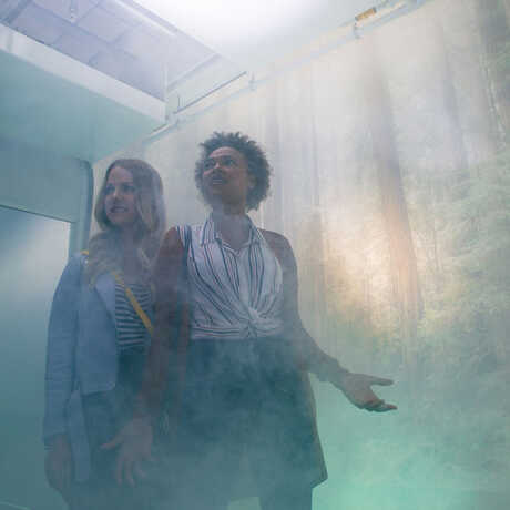 Two women shrouded in fog in the Fog Room in the Academy's Giants of Land and Sea exhibit