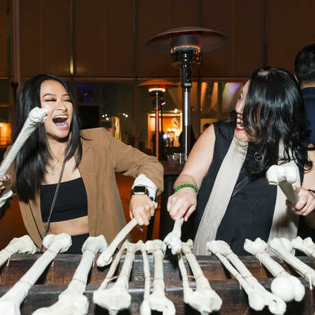 Two women play a bone xylophone at Party After Dark