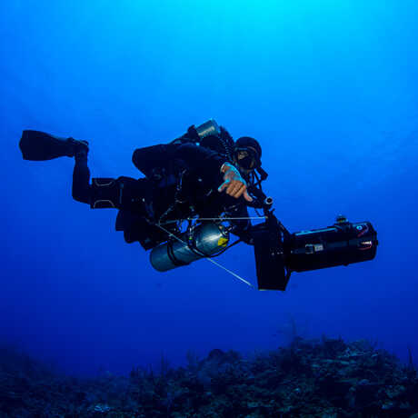 Dive Safety Officer Mauritius Bell descends into a brilliant blue canyon off Grand Cayman