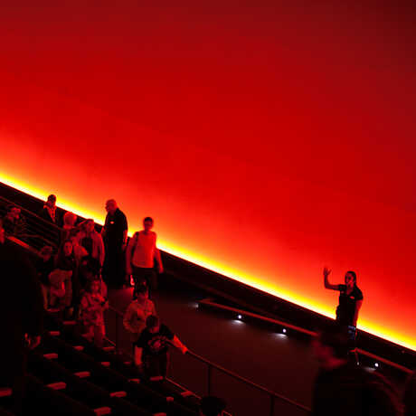 A crowd listens to a planetarium presented inside the vast, all-digital dome of Morrison Planetarium. 
