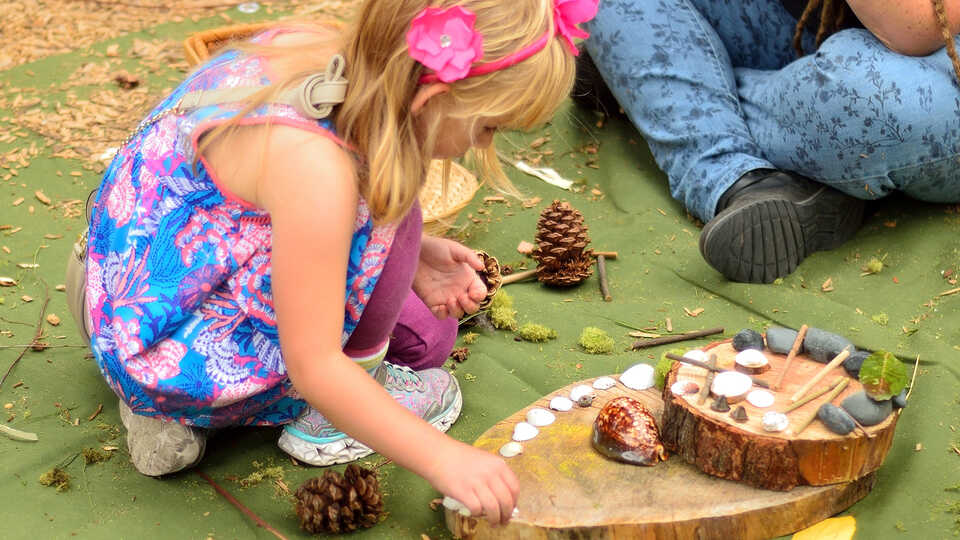 Girl making sculpture with found natural materials
